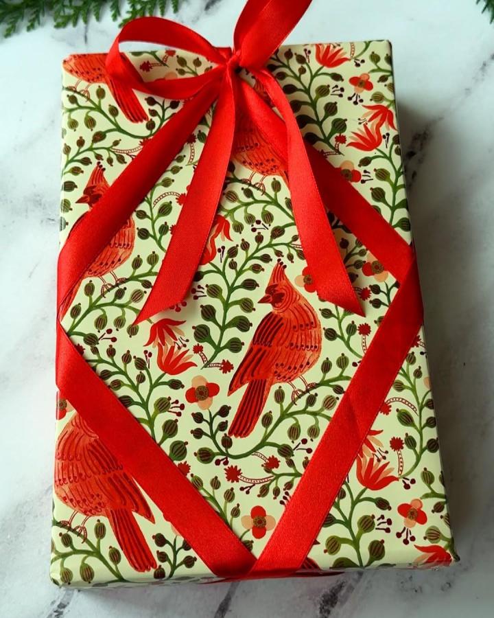 Botanical print gift wrap with diagonal red ribbon from @jeffandlaurenshow elegant christmas gift wrapping ideas with cardinal motifs