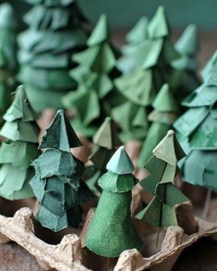 Green felt miniature trees from @inspiredbynaturesa displayed in cardboard egg carton.