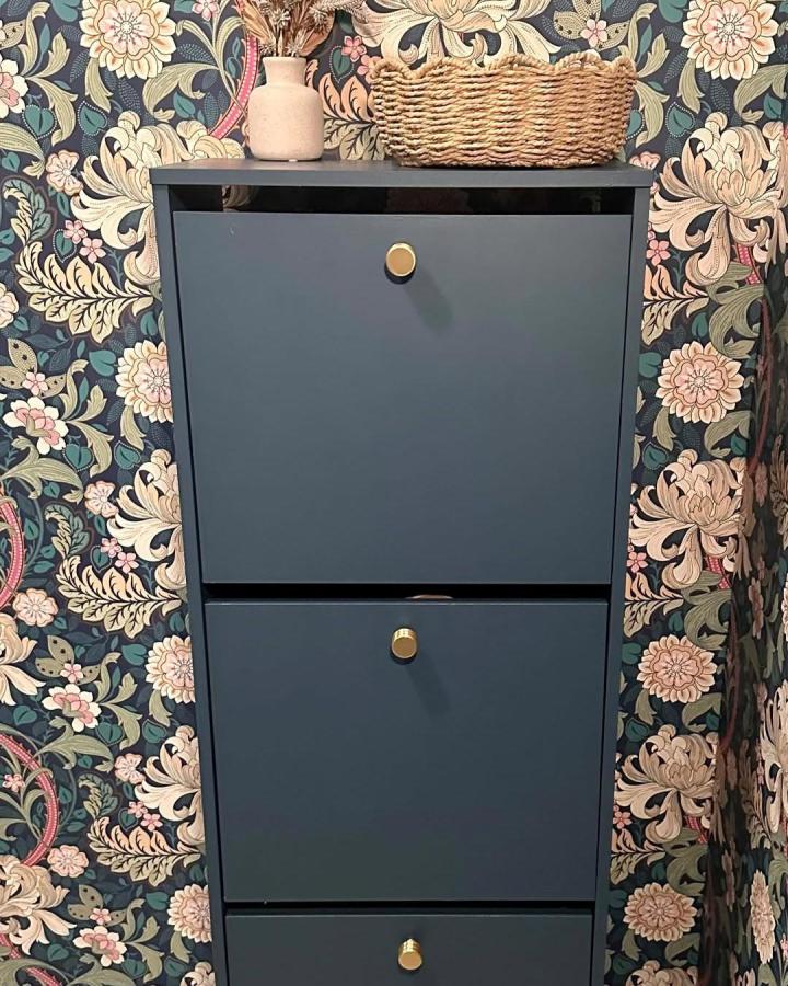 matte navy ikea bissa unit with brass knobs and wicker basket in floral wallpaper nook ikea bissa hacks & ideas
