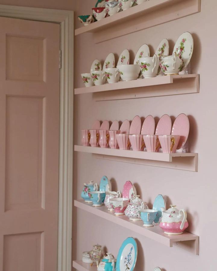 Pale pink floating shelves from Dainty Dress Diaries displaying vintage teacups, showcasing ikea mosslanda hacks & ideas for collections.