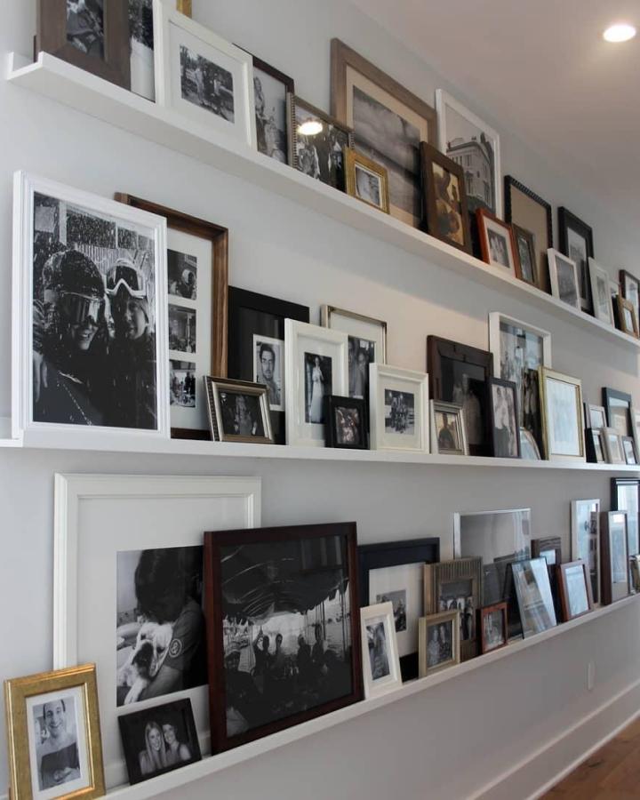 White picture ledges from @styleyourhome_ph displaying layered black and white framed photos in mixed finishes.