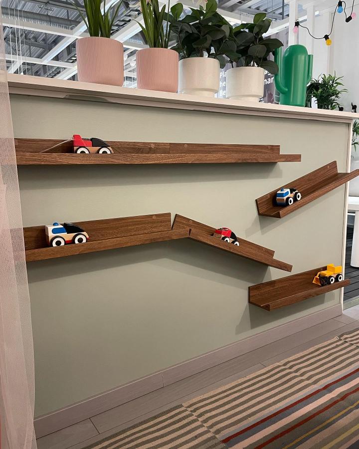 Walnut-stained toy car racetrack from @ikea_uppsala showcasing ikea mosslanda hacks & ideas with angled ledges.