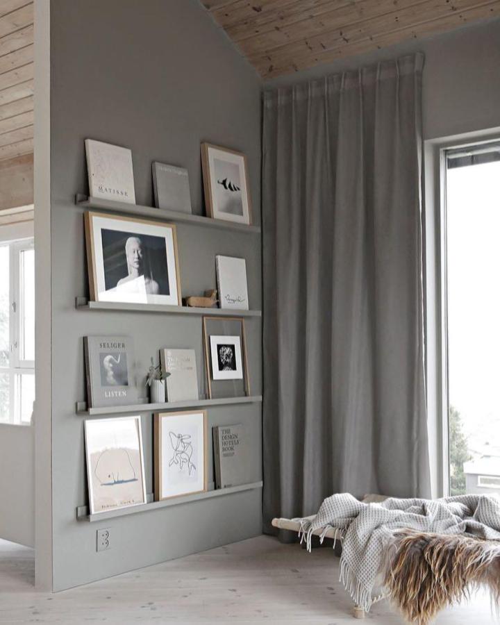 Gray picture ledge wall from @home_by_juul. Vertical arrangement displays framed art and prints.