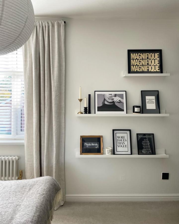 White stacked ledges from @thegingerhareofyorkshire displaying black framed art and typography prints in bedroom.