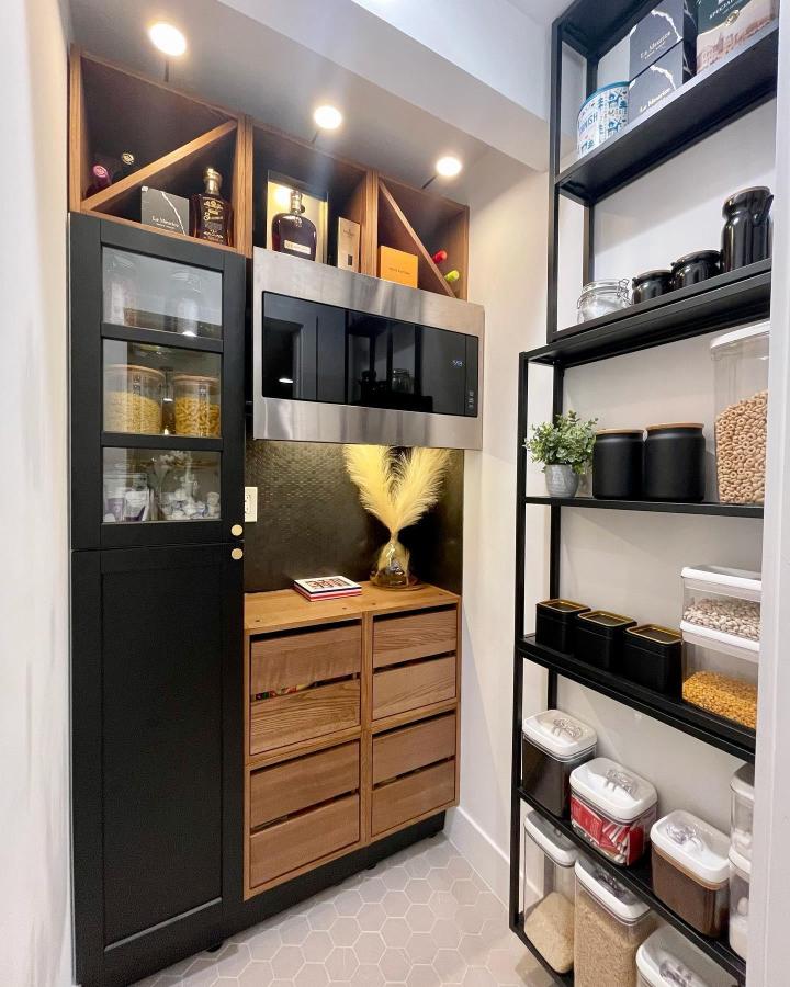 Matte black open shelving pantry from @dessy_french_touch. Coordinated canisters and clear bins for a tidy look.