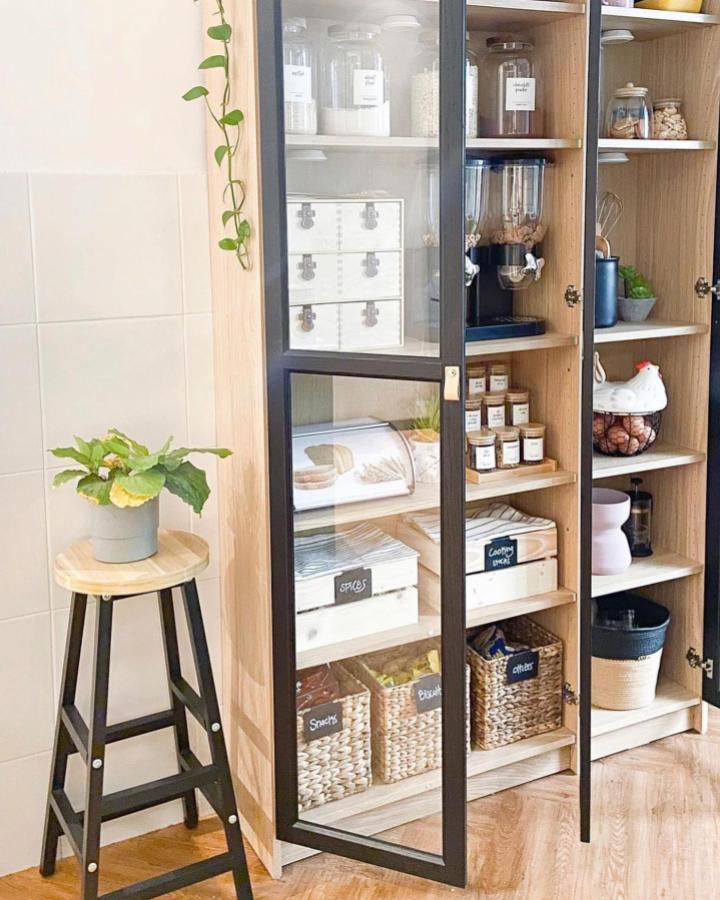 Black-framed glass pantry cabinet from @ikeamalaysia. Labeled jars and baskets, clean ikea pantry ideas.