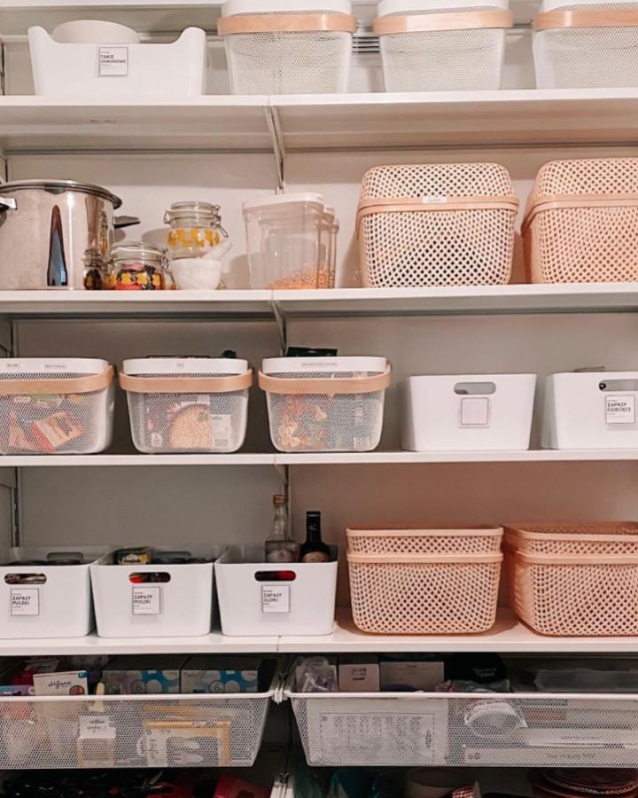 White mesh and bamboo-lid pantry storage from @architektporzadku. Labeled bins lined on open shelves.