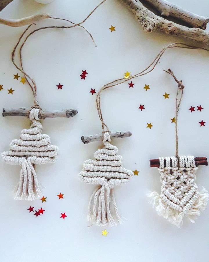 Cream driftwood macrame tree ornaments from artizinstudio with natural fringe and red gold star confetti scattered around