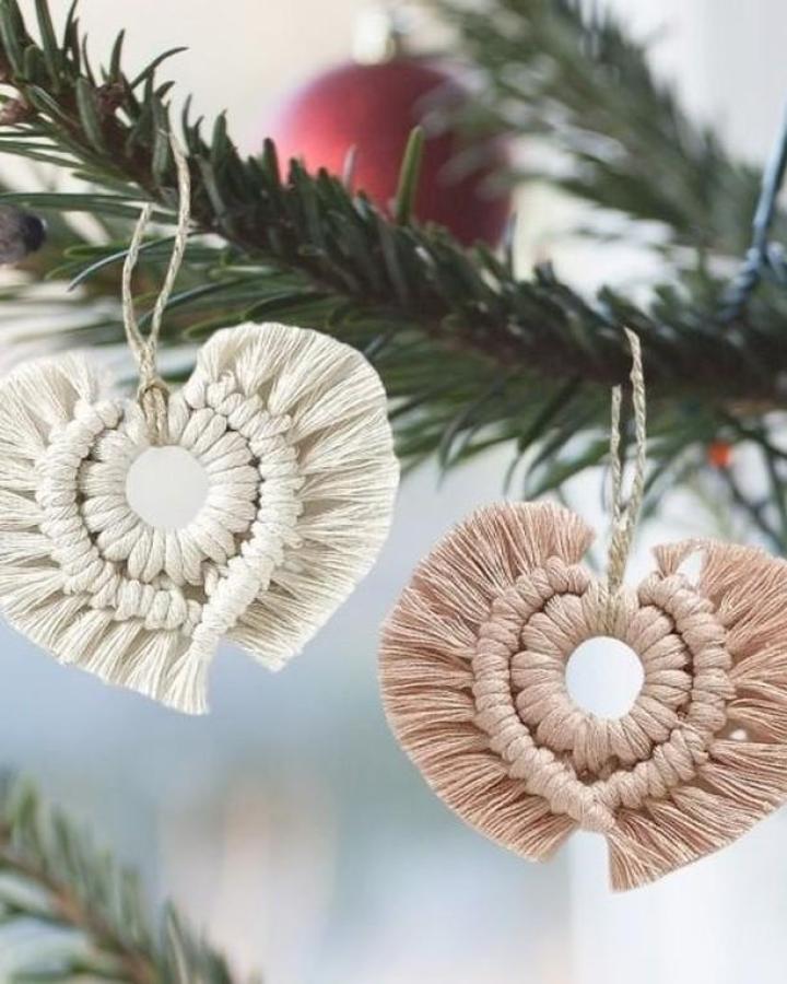 Cream and blush layered heart ornaments from @macrameforbeginners. Wrapped centers with fringe edges hang on evergreen branches.