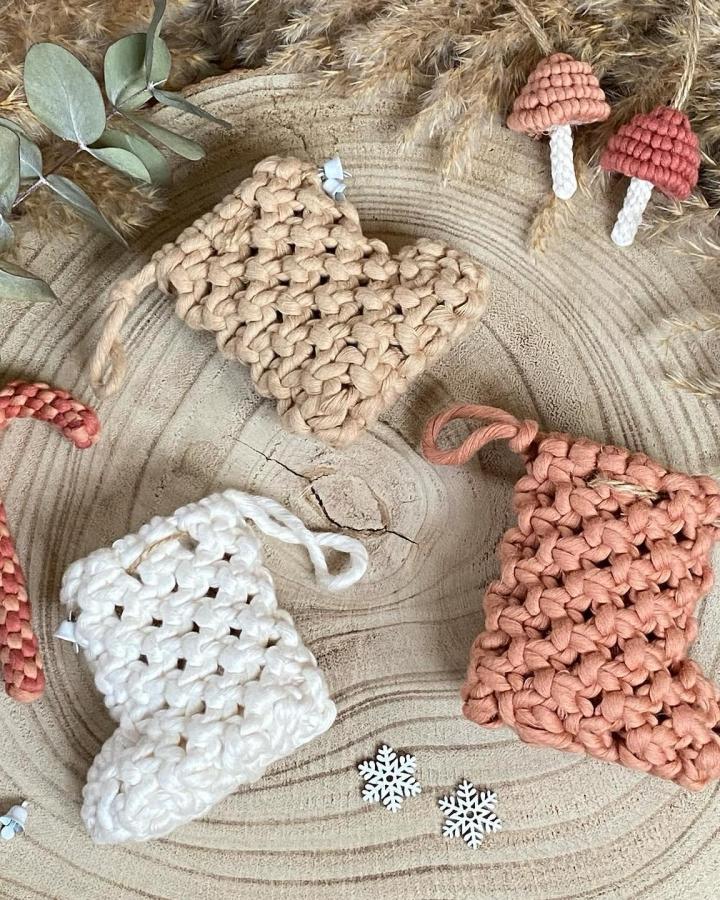 Beige, coral, and white knotted stocking ornaments from @lomiah.creations with mushroom accents on neutral backdrop.
