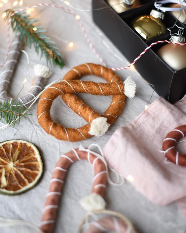 Burnt orange and blush pink wrapped candy cane ornaments from Macrame School with tassel details and wire frames.