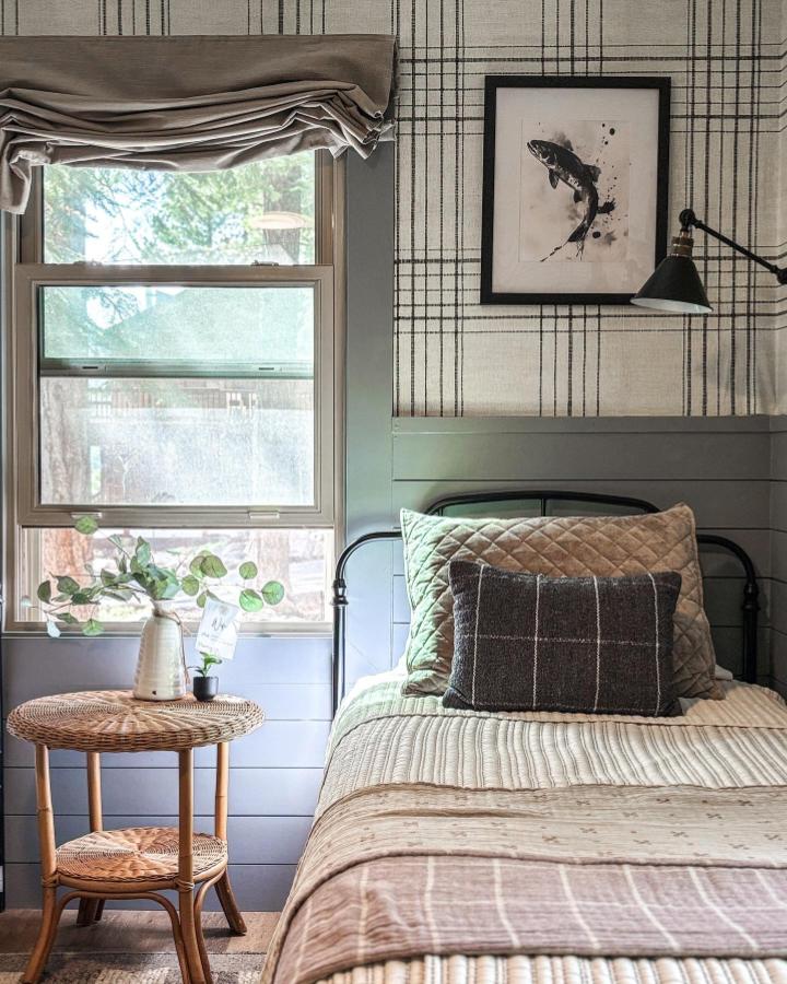 Beige and black plaid peel & stick wallpaper ideas in a cozy bedroom with wicker side table and quilted bedding from @surryplace.