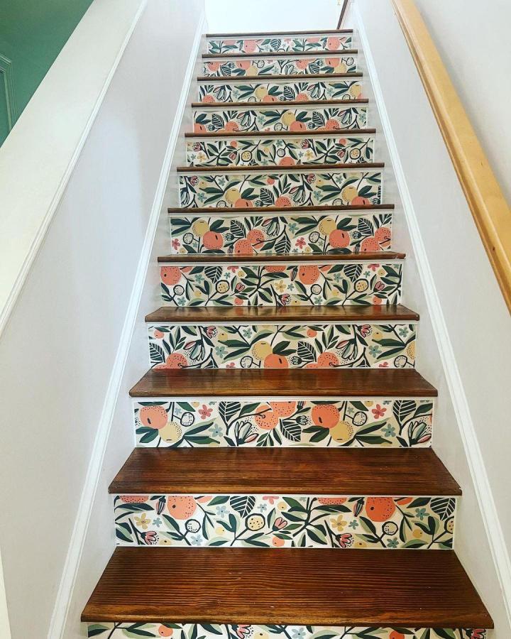 Colorful citrus patterned peel & stick wallpaper ideas on stair risers with dark wood steps from @wallpops. Bright and playful home decor upgrade.