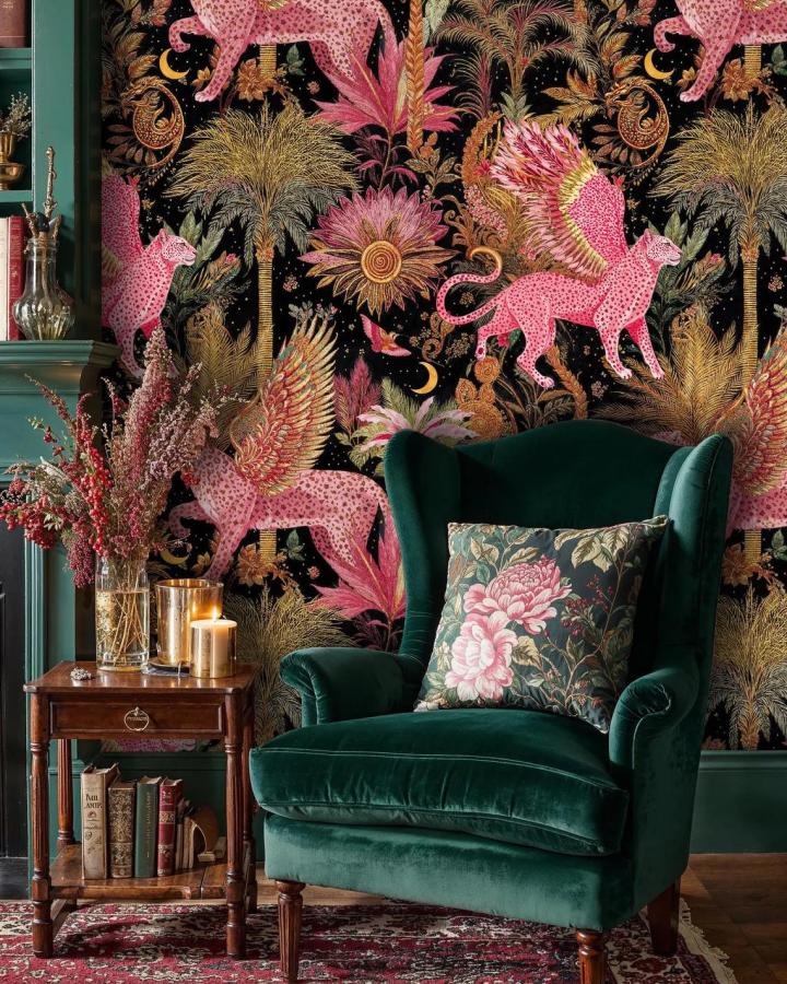 Pink winged leopard and gold palm tree peel & stick wallpaper ideas from NoireaWallCoverings with dark green velvet chair and floral cushion.