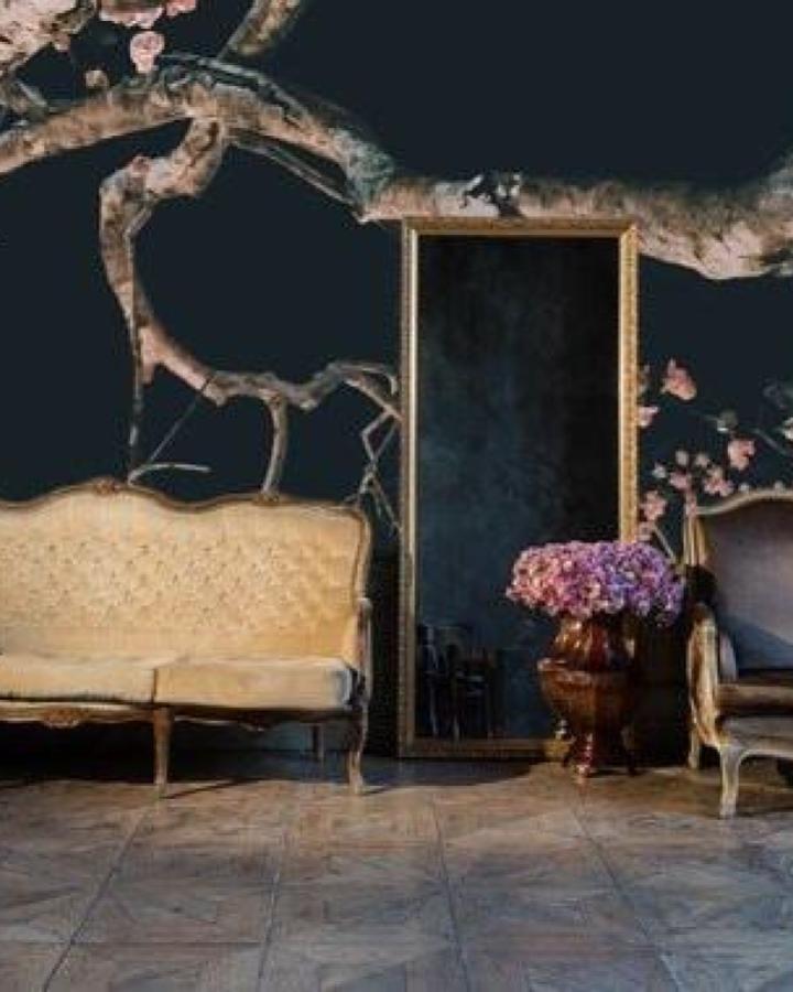 Dark floral peel & stick wallpaper ideas in vintage living room with cream sofa and antique mirror