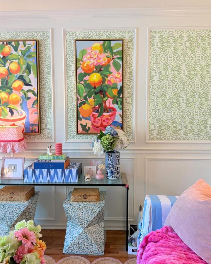 Light green patterned peel & stick wallpaper in living room with bright fruit art and floral decor from @chandlerbeasley.creative. Subtle textured wall panels.