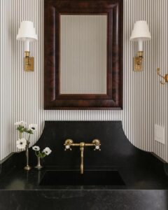 Black and white pinstripe wallpaper in bathroom from WallpaperTailor with brass faucet and framed mirror.
