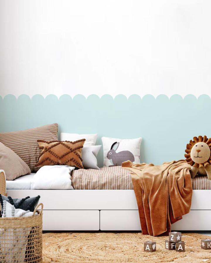 Soft blue scalloped peel & stick wallpaper ideas in children's bedroom with cozy pillows and warm blanket from MadeofSundays.