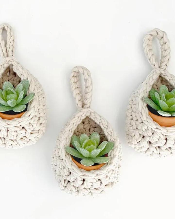 Cream crochet hanging holders from SimplyMadeByErin showcasing succulent planter ideas with small green succulents in terracotta pots.