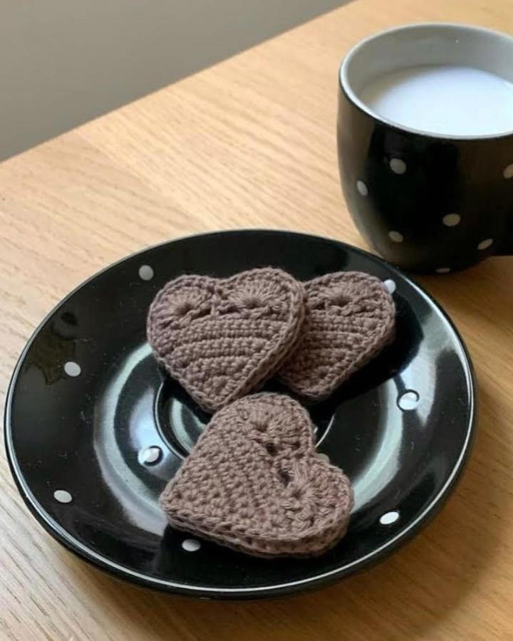 brown crochet heart decorations on black polka dot plate from @mo.design.it crochet valentines ideas