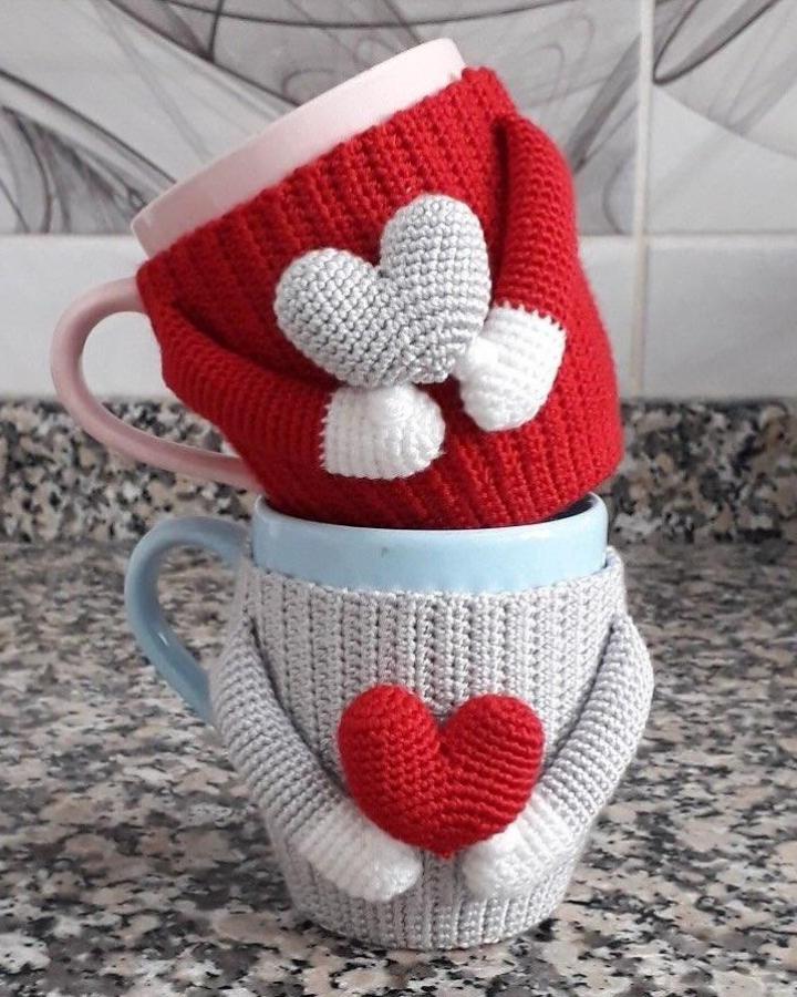 Red and gray crochet cup warmers with heart shapes from @stitch.n.go. Cozy crochet valentines ideas for mugs.