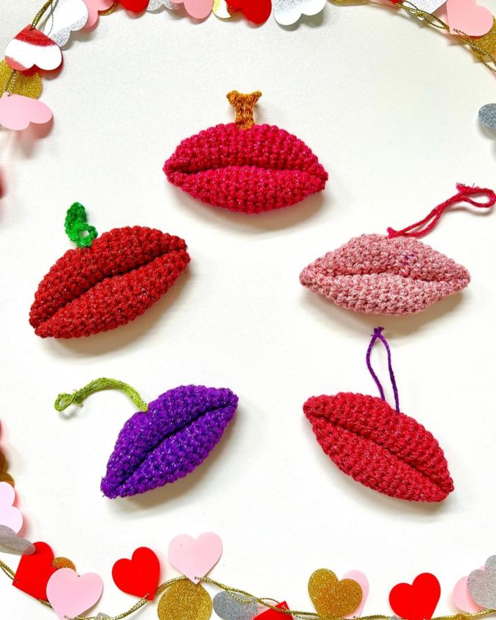 Bright red, pink, and purple crochet lips with green and brown stems, crafted by @essiebirdies, playful crochet valentines ideas accessory.