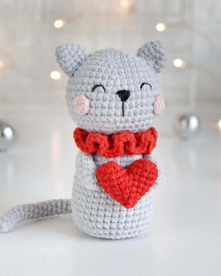 Gray and red crochet cat holding heart with ruffled collar from @lucy_rose_toys crochet valentines ideas plush toy craft.