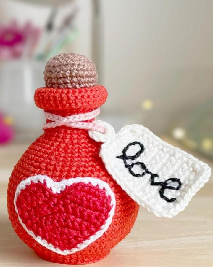 Red and pink crochet heart bottle with love tag from @erinmaycrochet. Cute handmade crochet valentines ideas craft.