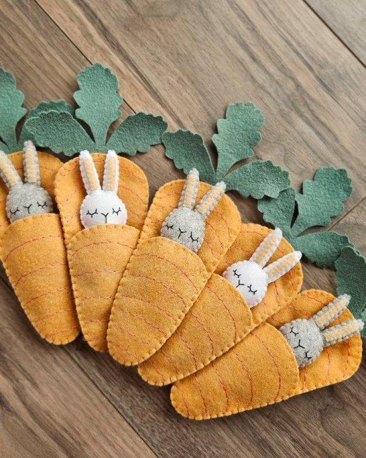 orange and green felt bunny carrot pouches from @the.felted.fawn featuring sleepy Easter bunny crafts for adults with pipe cleaner ears