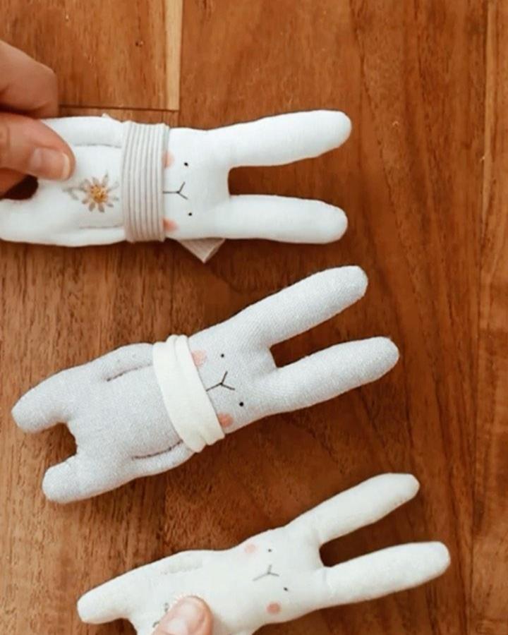 White and soft fabric easter bunny crafts for adults from @vanessa.sews.magic with tiny scarves and embroidered details on wood background.