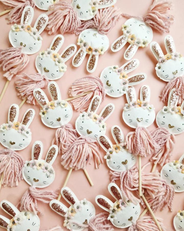 White bunny faces with glitter ears and pink yarn tassels from @_bysadie_. Easter bunny crafts for adults with floral crowns.
