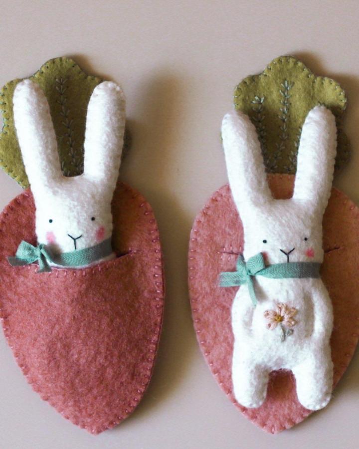 White felt bunny in dusty pink and green felt carrot pocket craft from @vanessa.sews.magic detailed with embroidery and pastel ribbon for easter bunny crafts for adults