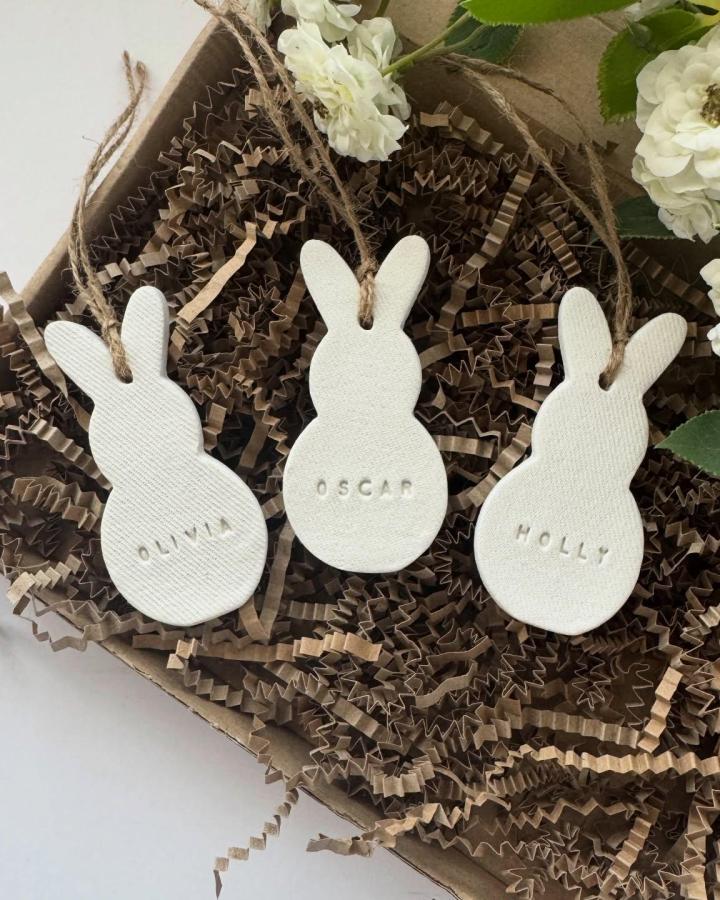 white textured clay bunny ornaments with jute twine from @hollyemilydesigns easter bunny crafts for adults personalized name tags in rustic packaging