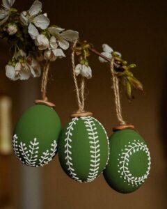 olive green embroidered Easter eggs from @tvorit_a_lubit hanging on flowering branch with rustic twine loops
