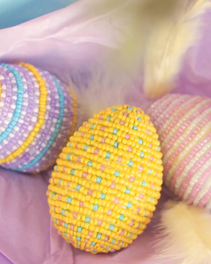 pastel colorful bead covered Easter eggs from @sostrenegrene displayed on soft fabric detailed texture and bright hues