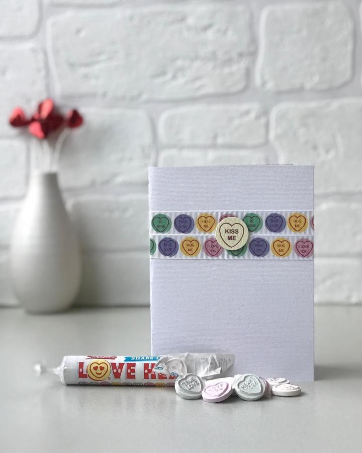 Pastel candy heart embellishments and wooden accent on a white handmade valentines card ideas from @lornakylecards. Simple and charming design.