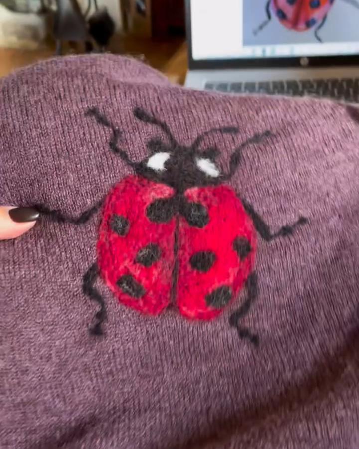 Red and black wool needle felted ladybug on purple knit fabric from @alicebrowncreations. Cozy textured ladybug crafts for adults.