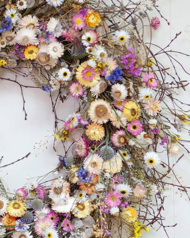 Dried pastel wildflower and twig wreath from @laylarobinsondesign featuring natural rustic spring wreath ideas.