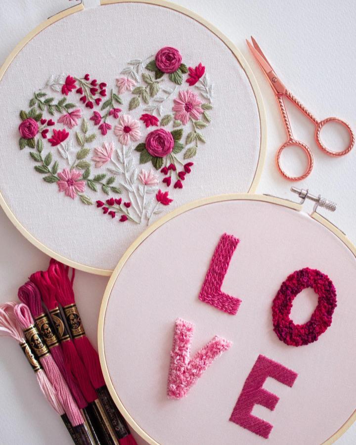 Pink and red embroidered heart and LOVE hoops with floral details and cotton threads for valentines crafts for adults from @byalyploof. Bright and textured needlework.