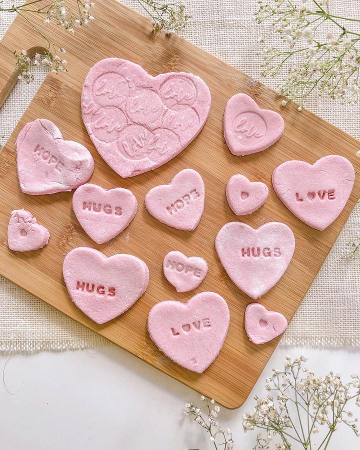 pink salt dough hearts with stamped words on wooden board from @our.playroom.diary valentines crafts for kids keepsakes and decorations
