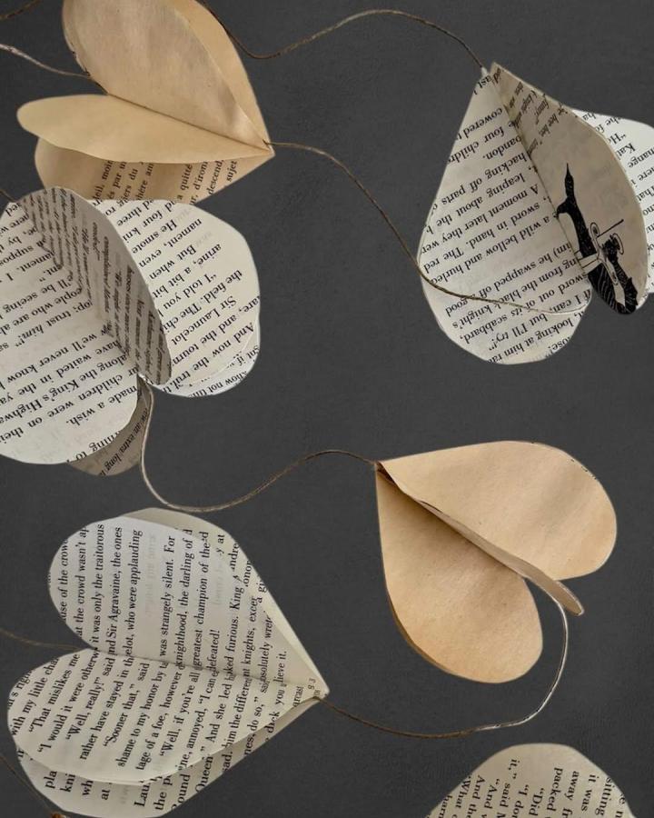 Vintage book page and craft paper hearts garland from @thesimplesunday used in valentines paper craft ideas with rustic twine string hanging.