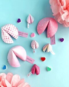 Pink and white heart-patterned paper fortune cookies from @craftsmithco with colorful heart embellishments Valentines paper craft ideas