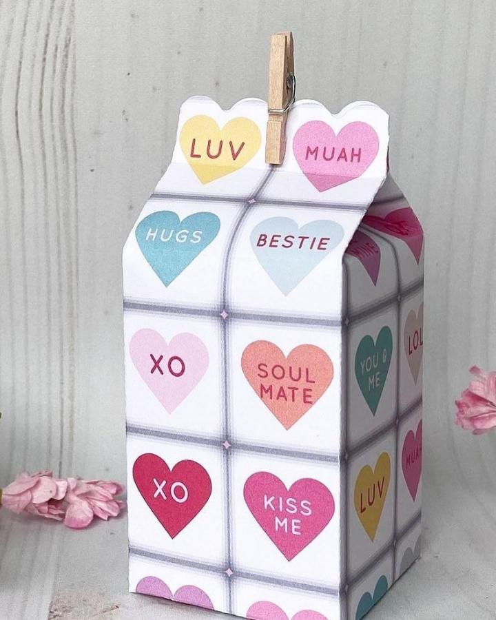 Pastel conversation heart patterned paper box with clothespin clip from @craftingwithkatherine. Valentines paper craft ideas with colorful love messages.