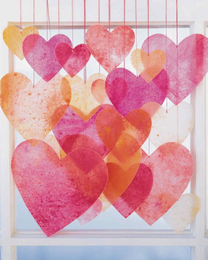 Translucent watercolor hearts hanging in window from @marthastewart soft layered valentines paper craft ideas decoration.