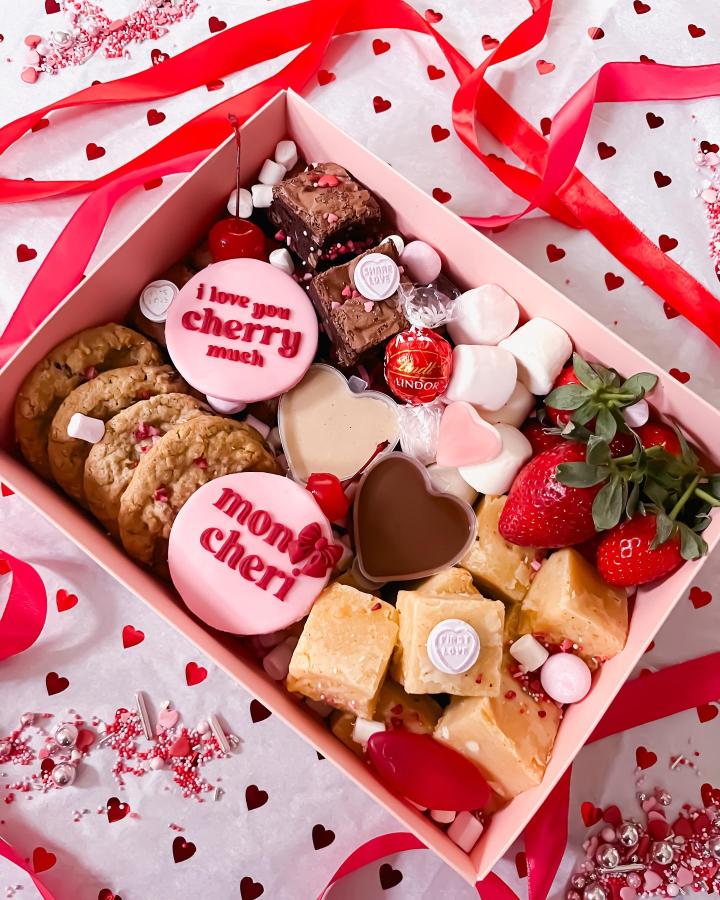 pink and red Valentines treat ideas gift box with cookies, fudge, chocolates, strawberries, and marshmallows from @dribblecakes