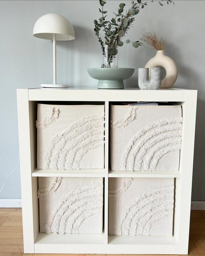 cream textured fabric inserts in white ikea kallax shelving from @das_kreativ_haus with subtle rainbow embroidery for cozy decor
