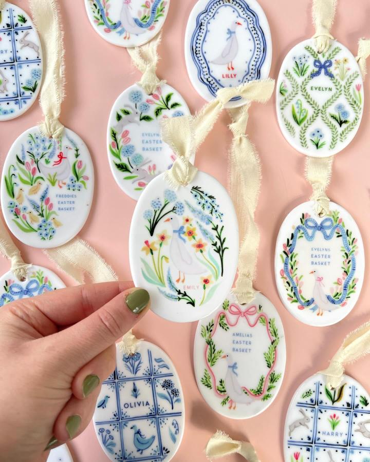White oval clay tags decorated with pastel florals and names, handmade easter clay craft ideas from @forestclayceramics.