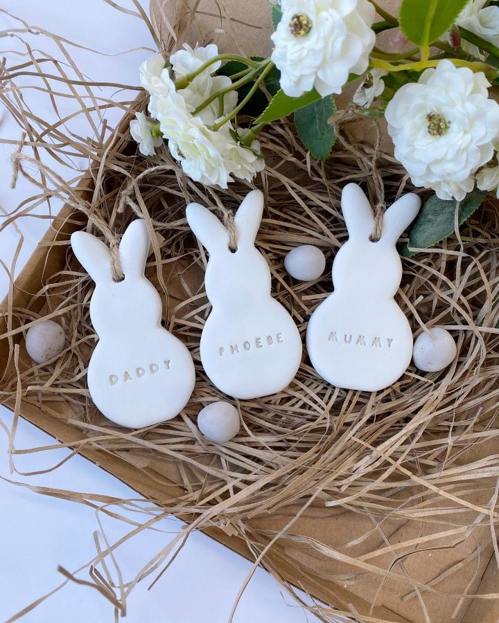 white clay bunny tags with names on straw nest from @astrids_werkstatt Easter clay craft ideas decoration