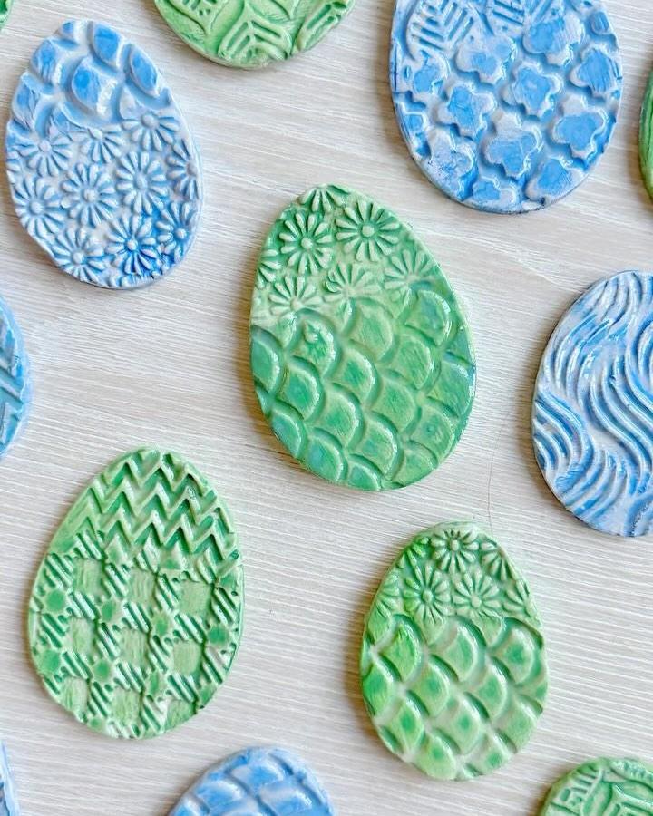 Green and blue textured clay Easter eggs with floral and geometric patterns from @englishstamp inspired easter clay craft ideas.