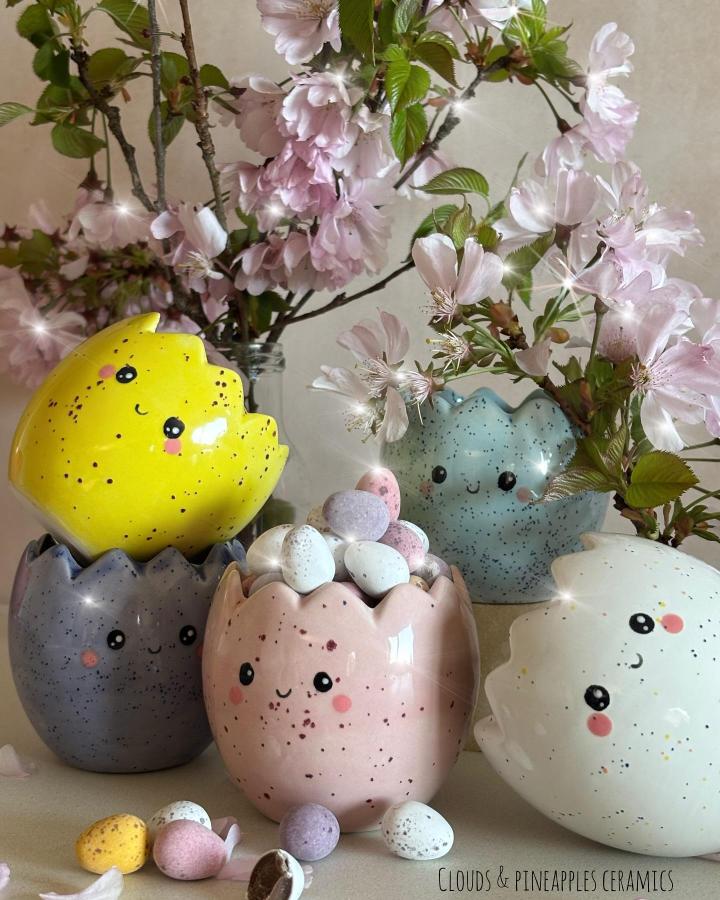 Yellow, pink, purple speckled cracked egg plant pots from @clouds_pineapples filled with pastel eggs and cherry blossoms for easter clay craft ideas.